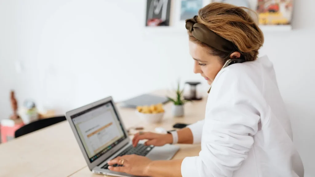 Woman using a softphone on her laptop with a headset while working from home